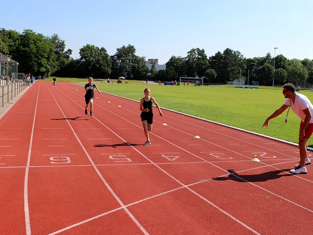 Läufer sprinten über die Tartanbahn.